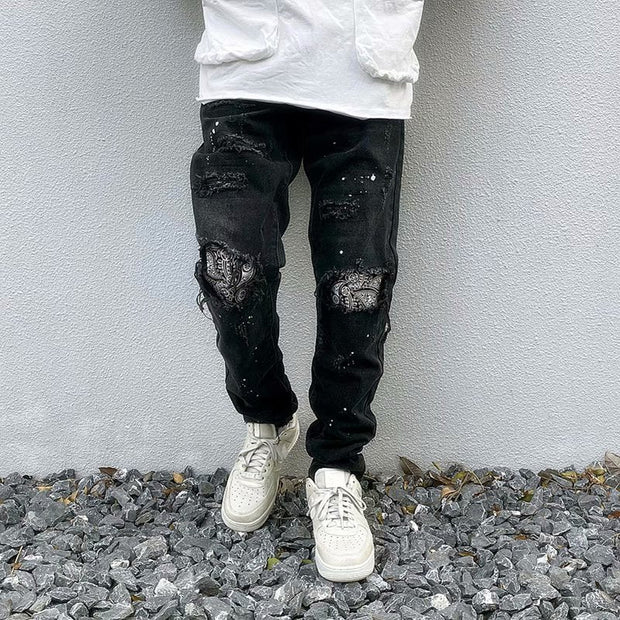 Raw-edge appliquéd cashew flower splattered straight ripped black jeans