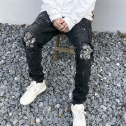 Raw-edge appliquéd cashew flower splattered straight ripped black jeans