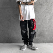 Raw-edge appliquéd cashew flower splattered straight ripped black jeans